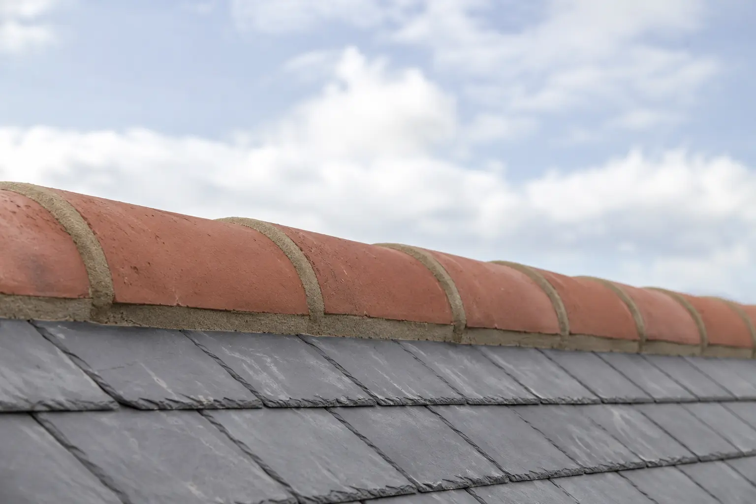 Clay ridge tiles bedded along a roof ridge
