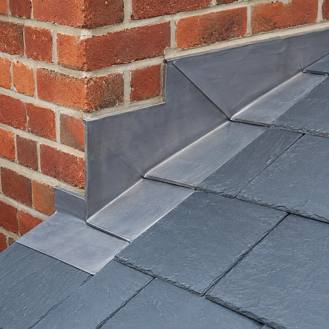 Fresh lead flashing dressed around a brick chimney