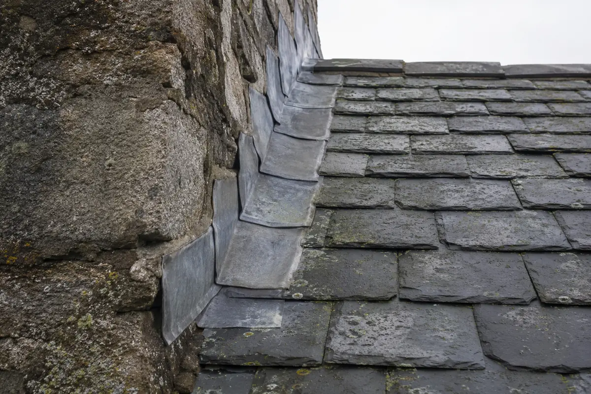 Granite wall meeting slate roof and lead flashing in Dún Laoghaire