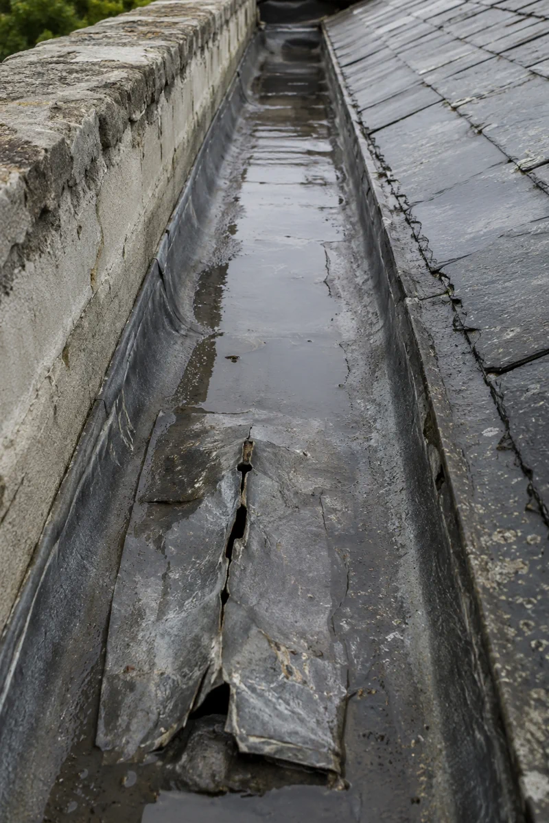 Split and perished lead in a parapet gutter on a Dublin period roof