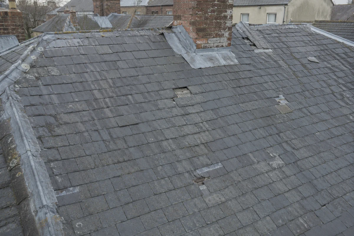 A tired period slate roof showing slipped slates across the whole slope in Dublin