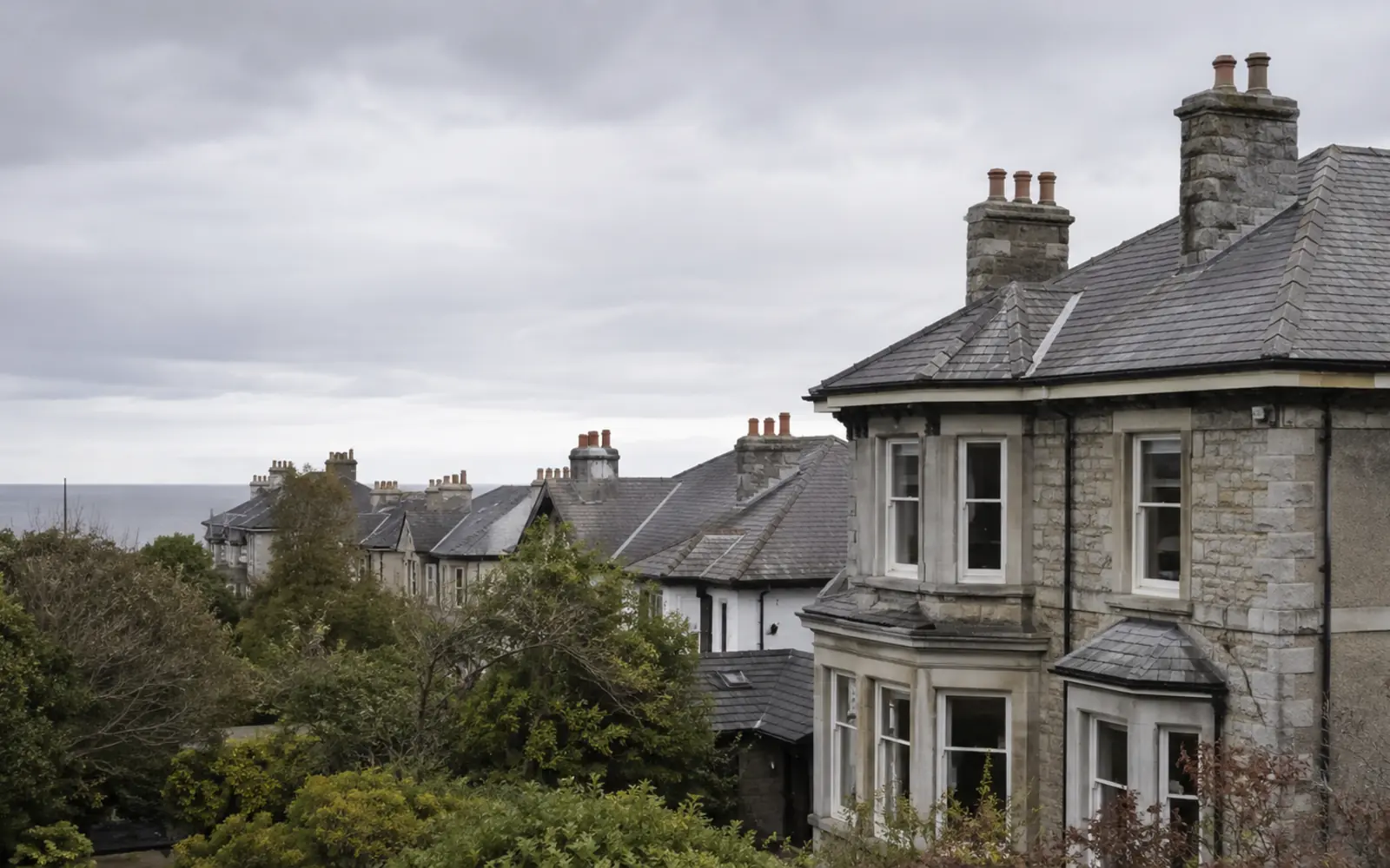 A period villa with a hipped slate roof and mature trees in Blackrock, County Dublin