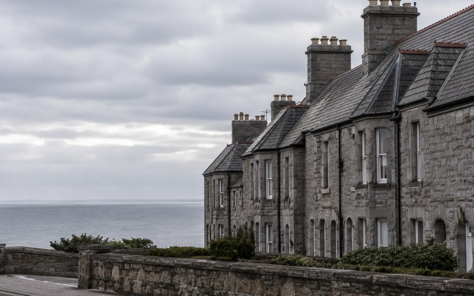 A granite Victorian terrace with steep slate roofs and tall chimney stacks in Dún Laoghaire