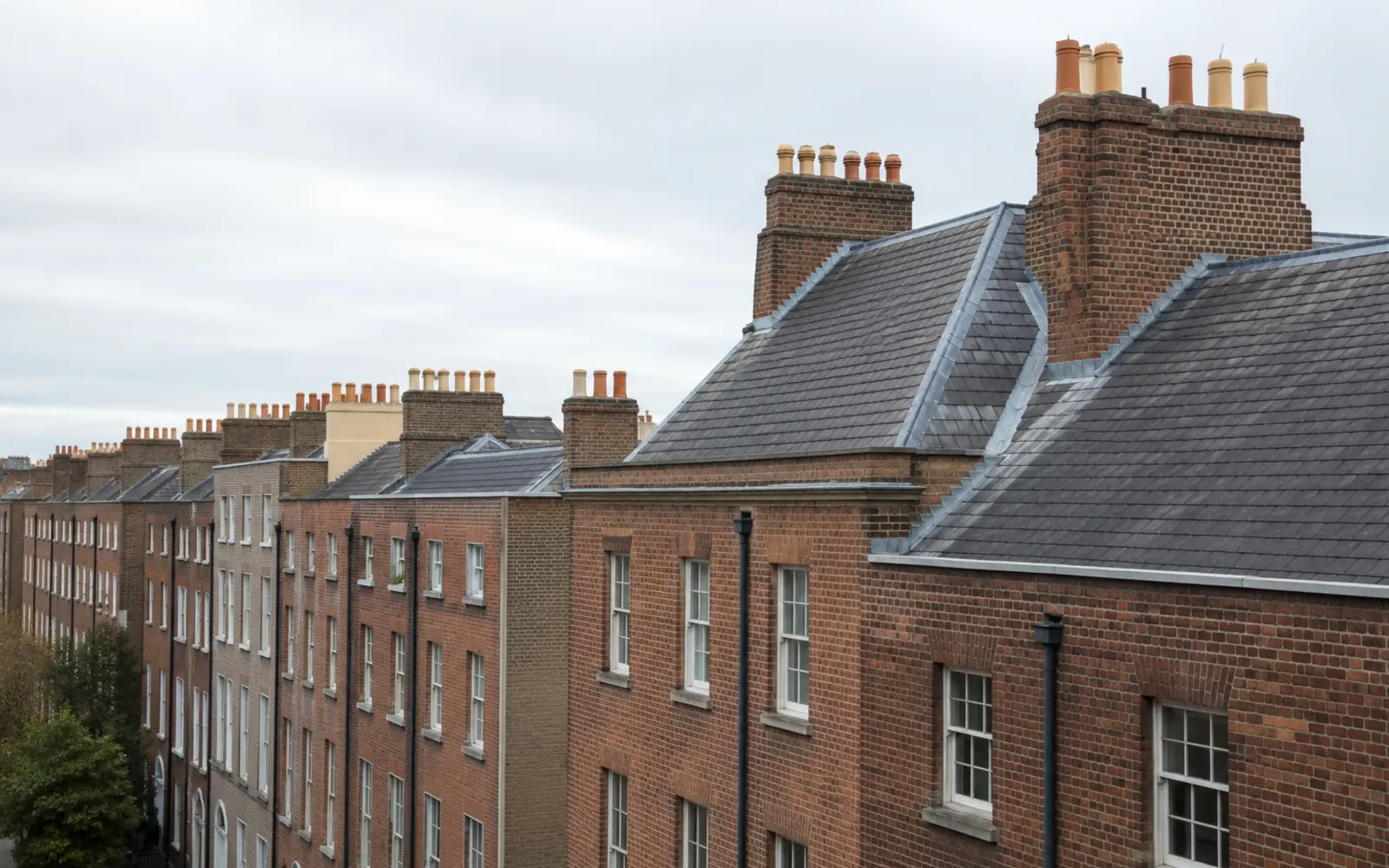 Georgian townhouses with parapet roofs and tall chimney stacks on a Dublin square
