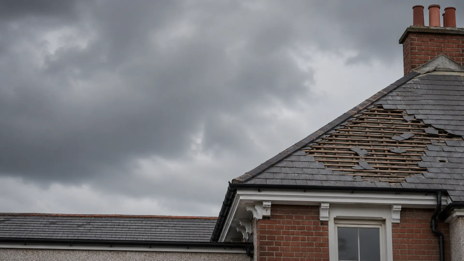 Storm-damaged Dublin roof with lifted slates and exposed felt after heavy rain