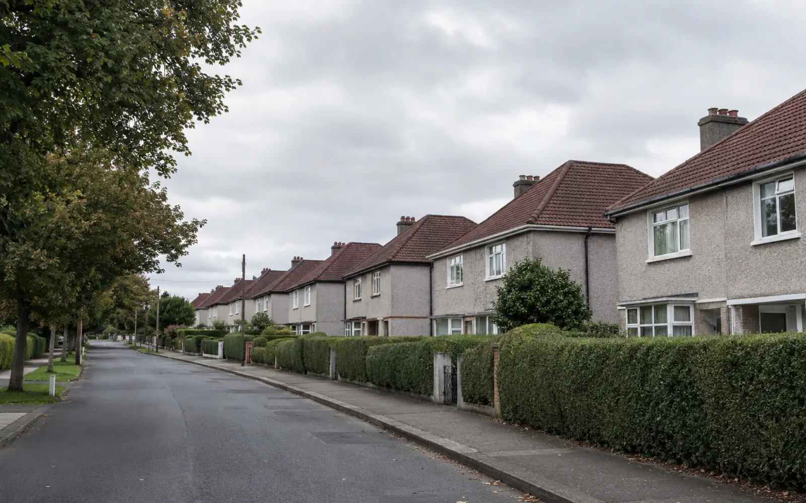 1930s to 1950s semis with hipped tile roofs on a wide tree-lined avenue in Whitehall, Dublin